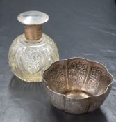 An Eastern silver bowl, of lobed form having decorative floral panels, along with a silver capped