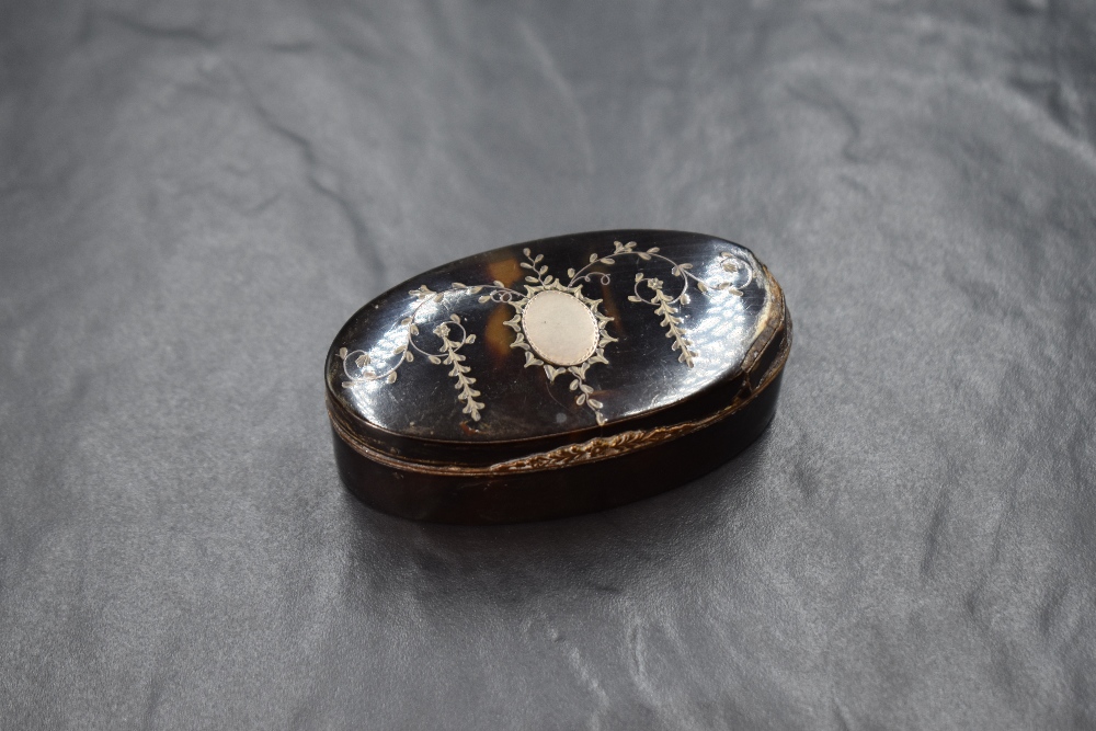 A 20th century white metal inlaid tortoiseshell trinket box, of hinged oval form having a vacant