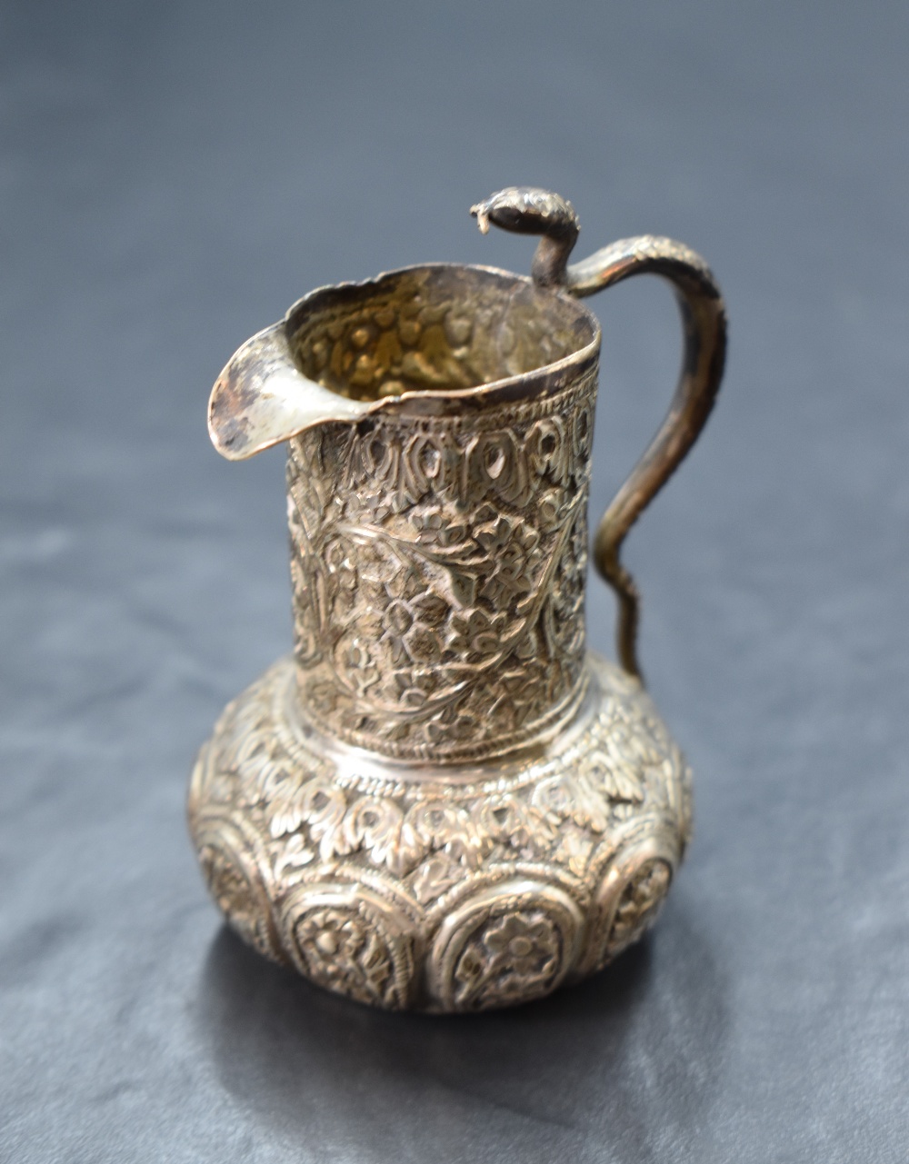 An Eastern white metal cream jug, of bulbous form having a narrow spout opposed by a handle in the - Image 3 of 3