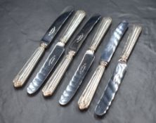 A cased set of six George V silver handled knives, having embossed decoration to the handles and