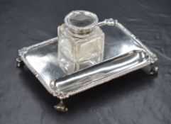 A George V silver inkwell stand, of rectangular form having scroll and gadrooned rim, with a