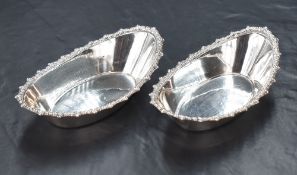 A pair of Edwardian silver dishes, of oval form having gadrooned rims, marks for London 1905,