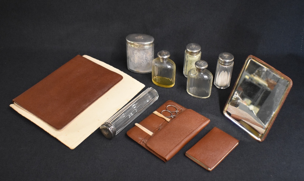 An early 20th century cased travelling set, the brown leather case with protective cover