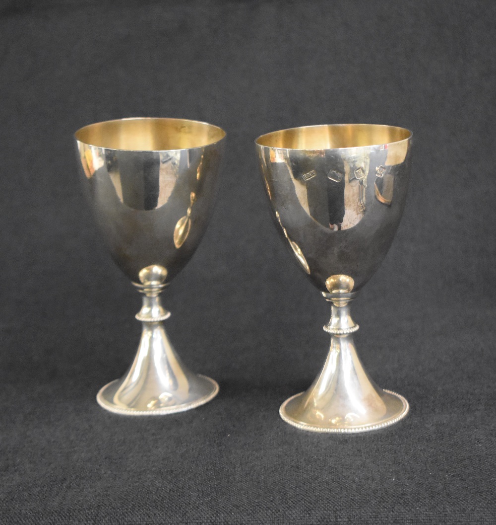 A pair of Elizabeth II silver goblets, of traditional form with gilt interior raised on a knopped