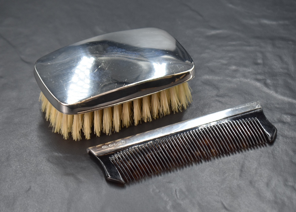 An Elizabeth II silver mounted gentleman's hair brush, of plain rectangular form, along with a