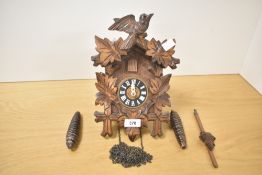 A 20th century Black Forest style cuckoo clock, hand carved with bird and leafs, A/F