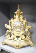 A gilt metal 8 day mantel clock having enamel Roman dial flanked by a pair of recumbent lions within