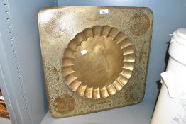 A large middle eastern charger having scalloped centre and engraved floral patterns, w50cm