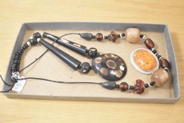 Two large beaded statement necklaces, one of carved wood and the other of glass and faux amber