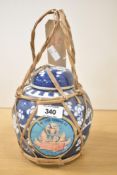 A vintage Chinese blue and white ginger jar decorated with prunus, bound in straw having