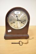 A early 20th century Wales & McCulloch mahogany 8 day mantel clock, the arched top decorated with