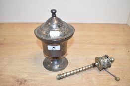 A brass lidded urn, engraved with floral patterns, supported on a circular base, h19cm, sold