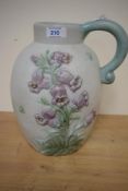 A large early 20th century Danesby ware ceramic jug, decorated having blue bell reliefs on an