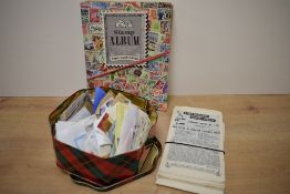 A tin of assorted postage stamps, three part filled stamp albums and a collection of vintage Stork