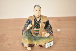 A Japanese stoneware figure of a seated man with a box by his side, h14cm Condition report:
