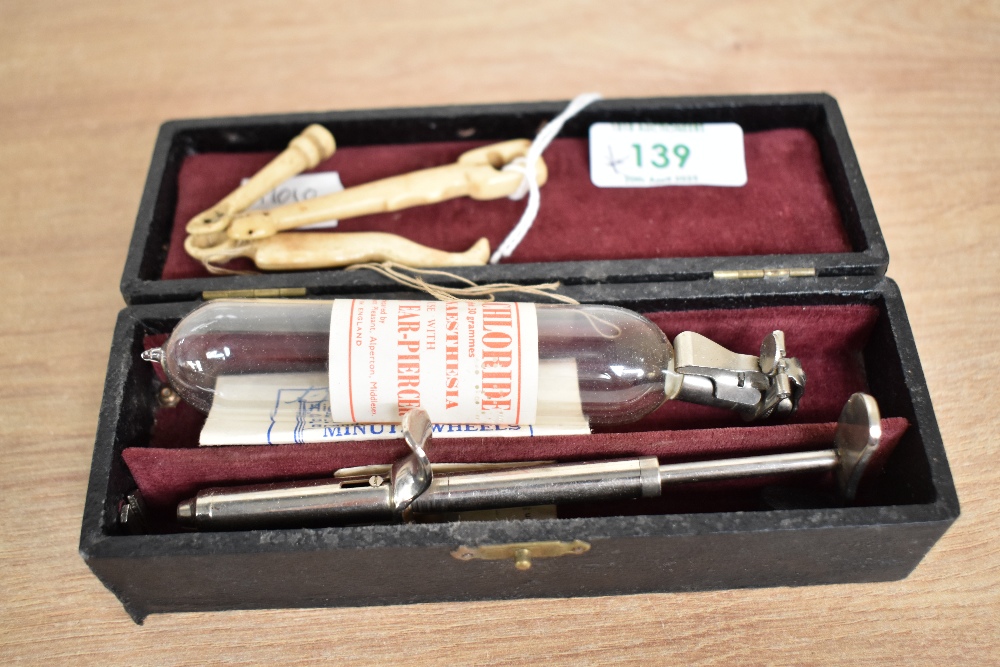 A vintage ear piercing kit, sold together with a pair of 9ct gold stud earrings weighing approx. 0.