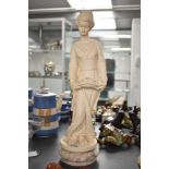 A cast composition figurine depicting a female holding a long basket flowers on marble base,