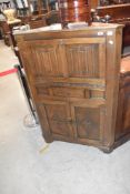 A Priory style oak corner bureau or cocktail cabinet, height approx. 132cm