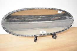 A L.R.T Borrowdale stainless steel dish tray having hand beaten edge, supported on three legs,