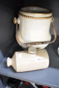 A Victorian slop bucket having a wicker handle and a stone ware hot water bottle.