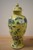 A Chinese porcelain yellow glazed and lidded baluster vase, moulded in relief with foliate detail