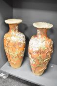 A pair of Japanese Satsuma porcelain vases, decorated with floral patterns and butterfly handles,