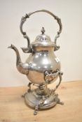 A silver plated spirit kettle and stand having shaped handle and spout, raised on a footed stand,