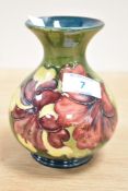 A Moorcroft Hibiscus pattern vase of baluster form, having tube lined decoration and raised on a
