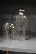 A clear glass dome cover, h22.5cm sold together with one other, (2)