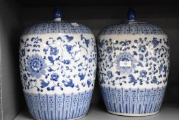 A pair of ceramic Chinese style ginger jars of pumpkin form with covers, decorated with blue scrolls