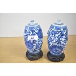 A pair of Chinese porcelain 'spirit' bottles, each of cylindrical form with a tapered, rounded