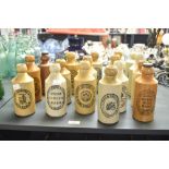 A collection of seventeen 20th-century stoneware ginger beer bottles from various makers and
