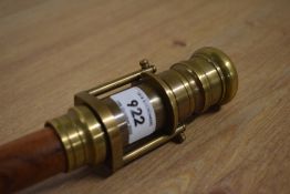 A thick shafted teak walking cane with a concealed brass 2 draw telescope mounted on top measuring
