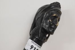 An ebonised walking cane measuring 88cm long with a cast metal figurehead a hole drilled 1.5cm