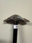 An ebonised shafted walking stick with a carved bone vulture or eagle handle and a brass ferrule