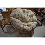 A vintage 'papasan' chair of circular form with floral cushion
