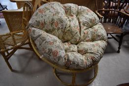 A vintage 'papasan' chair of circular form with floral cushion