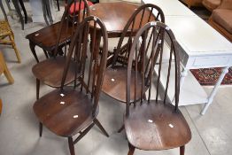 A set of four dark stained Ercol hoop and stick back dining chairs