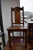 A Lakeland Arts & Crafts golden oak solid seat chair , having carved cruciform to back rail, stamped