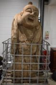 An impressive and monumental Chinese carved wooden Budai/laughing Buddha figure, modelled holding