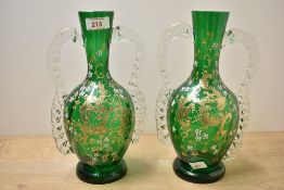 Two Victorian green glass vases, featuring enamel and gilt floral decoration, with two handles, 26.