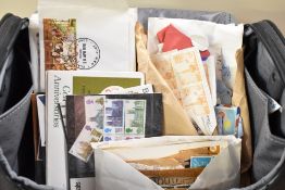 A selection of first day covers and loose stamps in a camera bag.