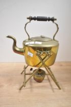 A late 19th to early 20th century brass spirit kettle on a stand with a burner, featuring a turned