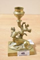 A Victorian cast brass deer candlestick, modelled as a kneeling doe before a tree, the trunk