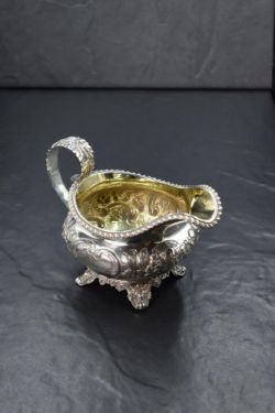 A Victorian silver cream jug, of circular form having a gadrooned rim, generous spout opposed by a