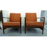 A pair of IB Kofod-Larsen for G-Plan teak framed armchairs, the loose cushions upholstered in orange