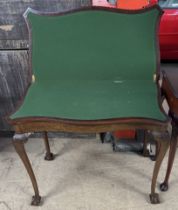 A mahogany card table with a serpentine top and baize interior on three leaf capped cabriole legs