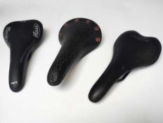 Three Bike Saddles including a Selle San Marco Regal with copper coloured rivets and rails,