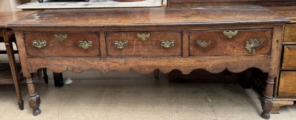 An 18th century oak dresser base with a planked rectangular top above three drawers,