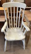 A white painted slat back kitchen elbow chair with a solid seat on turned legs and stretchers